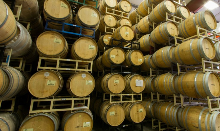 Wine Barrels at Rack & Riddle. Wine Barrels stacked in the Rack & Riddle cellar warehouse.