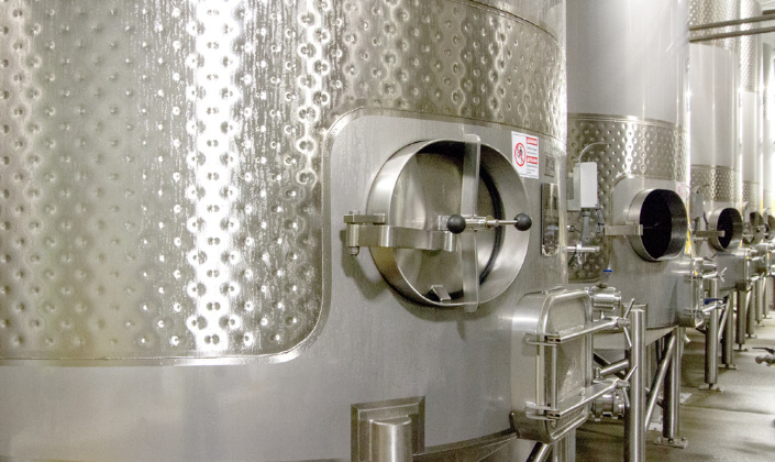 Massive stainless steel wine storage tanks at the Rack & Riddle Healdsburg, California location.