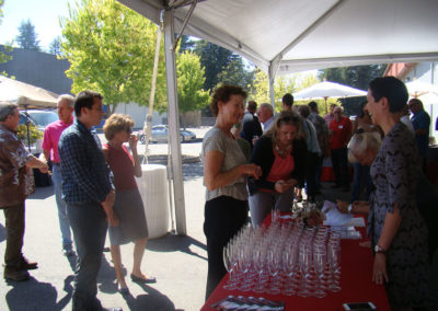 Our Business Development Client Services Specialist standing at a table full of sparkling wine glasses, talking to guests.