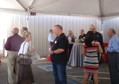 Bruce Lundquist talking to a small group of guests at the grand opening event in 2014.