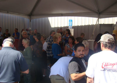 Guests talking to each other under a tent at the Grand Opening Event in 2014.