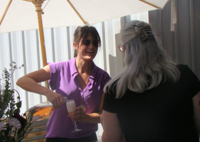 Jessica Pigeon, daughter of Rebecca Faust, pouring wine for a party guest.