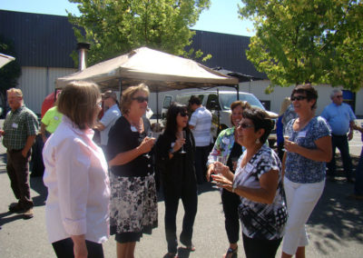 Guests talking to each other and holding glasses of sparkling wine in the event area at our grand opening.