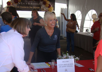 Rack & Riddle employee greeting guests under a tent at the “Welcome check-in table” at our Healdsburg Grand Opening in 2014.