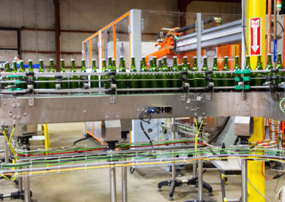 High-speed shot of bottles traveling down tirage bottling conveyer