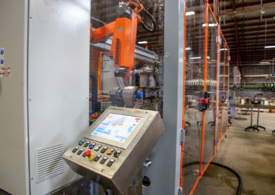 Side view of tirage bottling production line with the control panel shown in the foreground