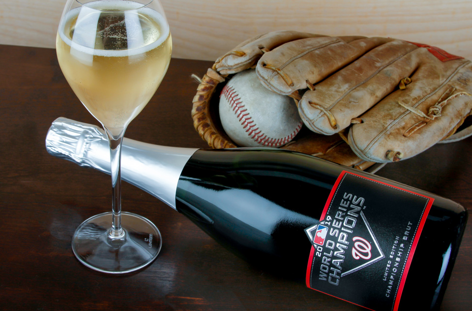 Washington Nationals 2019 World Series Champions Limited Edition Championship Brut Beauty shot of the Washington Nationals 2019 World Series Champions Limited Edition Championship Brut next to a baseball and glass of sparkline wine.